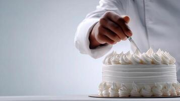 A person cutting a white cake with a knife photo