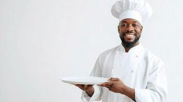 A black man in a chef hat holding a plate photo