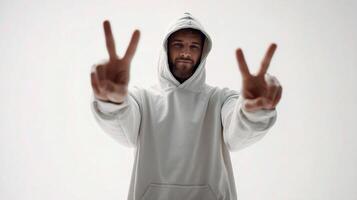 A man in a hoodie making the peace sign photo