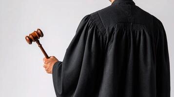 A judge in a robe holding a gavel photo