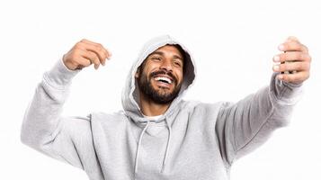 A man in a hoodie is smiling and holding his phone photo