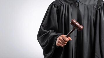 A judge holding a gavel and wearing a robe photo