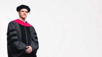 A man in a graduation gown standing in front of a white background photo