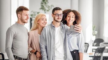 Selfie at work with colleagues. Multiracial workers looking at smartphone camera, guy makes photo in interior of modern office or about company and corporate culture for clients, copy space