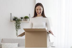 Woman unboxing cardboard box with protective foam pads inside after buying ordering online via internet a present photo