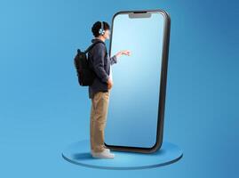 Side View Of Guy Using Large Cellphone Touching Screen Wearing Headphones Standing With Backpack Over Blue Studio Background. Panorama With Free Space For Text, Full Length photo