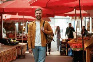 Front view, walking. Handsome man is on the street market or,, bazaar photo