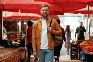Front view, walking., Handsome man is, on ,the street market or bazaar photo