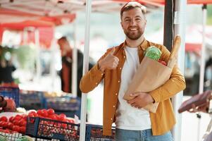 Collection, of ,products in,, paper bag. Handsome man is on the street market or bazaar photo