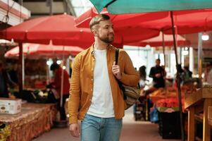 Going forward, looking at, products. Handsome man is on the street market or bazaar photo