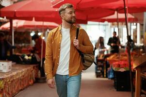 Going, forward,, looking at products. Handsome man is on the street market or bazaar photo