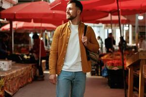 Front view, walking.. Handsome man is on the street market or bazaar photo