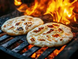 Cooking flatbreads over an open flame in a rustic setting photo