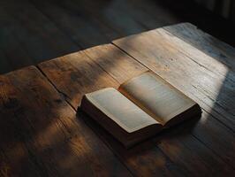 Open book on a wooden table with soft light illuminating pages photo