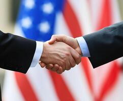 Handshake between two professionals in front of American flag photo