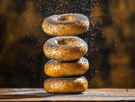 Freshly baked bagels sprinkled with poppy seeds tower on wooden table photo