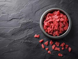 Freshly chopped beef placed in a bowl on a dark surface photo