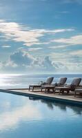 Luxury resort infinity pool overlooking the ocean with lounge chairs under a blue sky photo