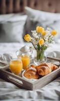 Breakfast on bed with croissants juice and flowers representing the joy of starting the day photo