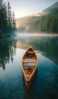 An old wooden canoe floating peacefully on a pristine lake surrounded by tall green trees photo
