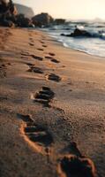 Footprints in the sand lead along a serene coastline at sunset creating a calming seascape photo