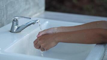 Child washing hands. Close-up of hands being cleaned at a public faucet. video