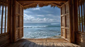 Ocean view from a traditional bamboo hut with open window shutters framing a tropical scene photo