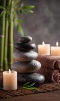 Zen stones stacked with bamboo, candles, and towels creating tranquil spa atmosphere photo