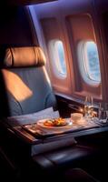 Luxury airplane seat with gourmet meal and drink service on tray table by the window photo