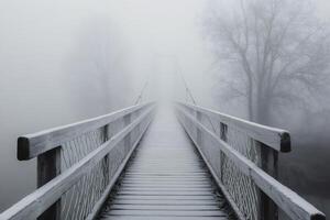 Suspension bridge disappearing into the fog on a frosty winter morning photo