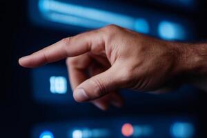 Programmer pointing finger to futuristic control panel interface in data center photo