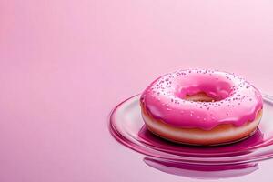 Delicious pink donut with sprinkles resting on glass plate on pink background photo