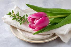 Pink tulip decorating a table setting for a festive spring celebration photo