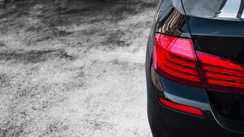 Black Sedan Car with copy space, Close-up rear view of a sedan car, with a focus on its rear taillight, automotive, vehicle. photo