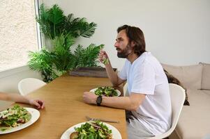 Man Enjoying A Healthy Salad Meal at A Dining Table photo