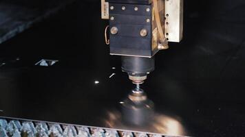 Laser cutting machine processing dark metal sheet, Precision CNC operation creating shapes in industrial fabrication video