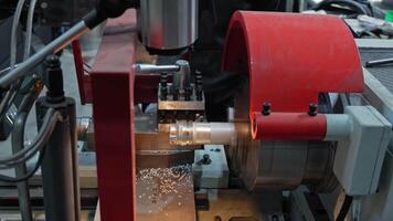 Metalworking lathe shaping cylindrical part with cutting tool, Industrial machining process with red protective housing video