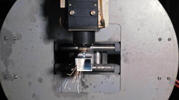 Laser cutting head positioned over metal pipe in CNC machine, Precision tube processing in industrial manufacturing setup video