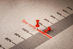 Red pin marks word Tax rate on paper background. Tax rate concept, Percentage of income and asset value that individuals or businesses are required to pay according to tax laws. photo