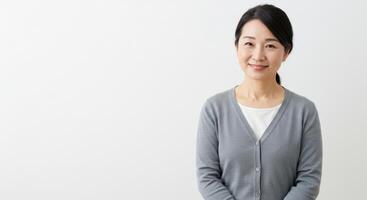 Smiling Middle Aged East Asian Woman in Casual Sweater Posing with Friendly Expression photo