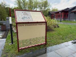 Moscow, Russia, April 25, 2025 Navigation board with detailed map and rules at entrance to Huamin park in Moscow, showcasing bilingual signage and elements of Chinese style in public space photo