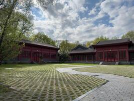 Moscow, Russia, April 25, 2025 Wide courtyard with gray paving stones and traditional Chinese style buildings in Huamin park. Calm space reflects cultural harmony and architectural elegance photo
