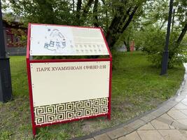 Moscow, Russia, April 25, 2025 Information stand with map and visitor rules at Huamin Park in Moscow features bilingual text in Russian and Chinese and decorative Asian style design photo