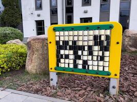 Educational play panel with rotating cubes in park setting. Designed to support cognitive development, coordination, and pattern recognition in young children through interactive learning photo
