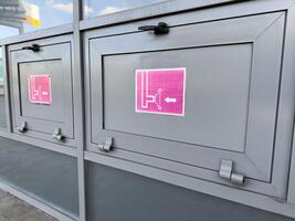Metal fire hose cabinets with emergency signs and pictograms indicating hose reel direction, installed on building exterior as part of public fire safety system and modern infrastructure photo