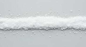 Strip of faux snow with scattered snowflakes on a neutral surface photo