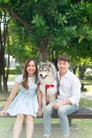 Asian couple love with cute dog at park photo