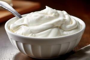 Sour cream in a deep white plate with metal spoon. photo
