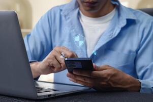 Person using smartphone and laptop with network security graphics photo