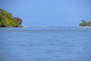 Calm sea view with green cliff and bright blue sky photo